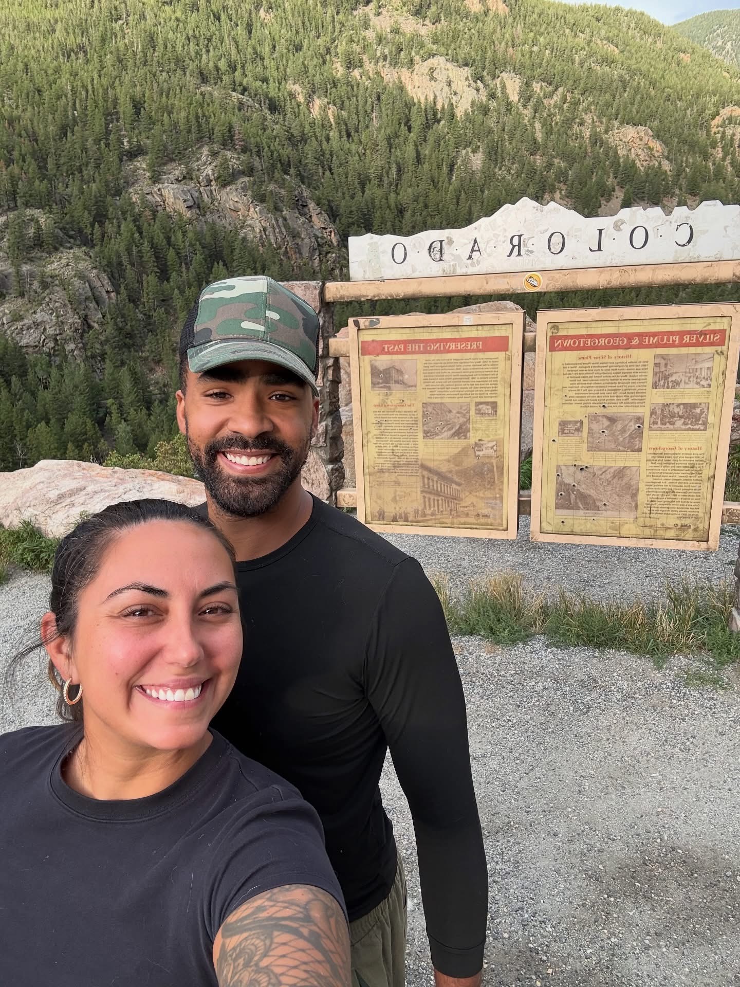 Two hikers taking a selfie beside Colorado historical signs