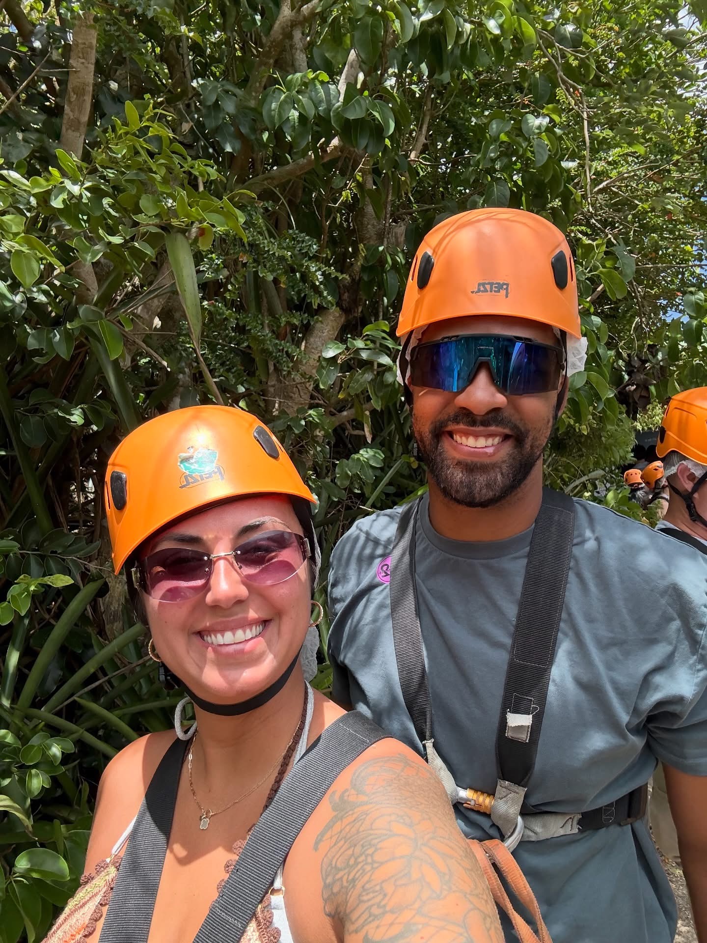 Two adventurers wearing orange helmets and safety harnesses
